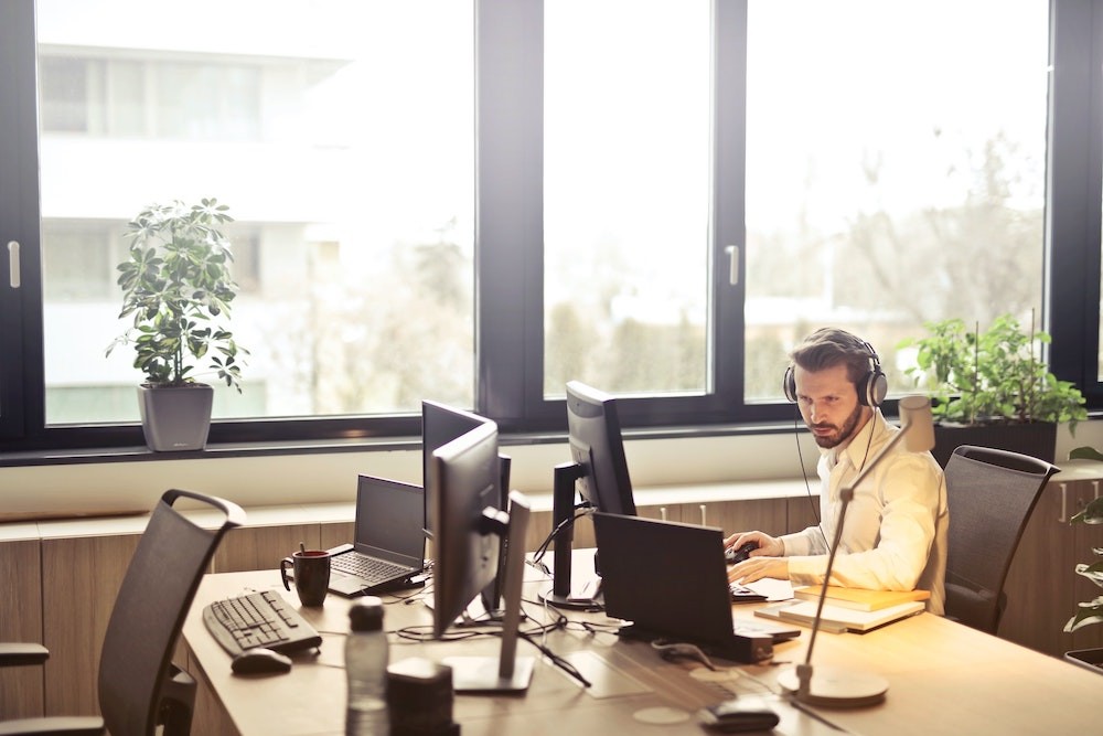 IT Services support guy at computer with headphones on